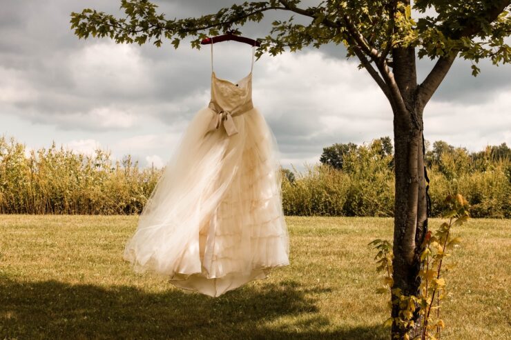 Νυφικό για την τέλεια μέρα white wedding dress hanging on green tree