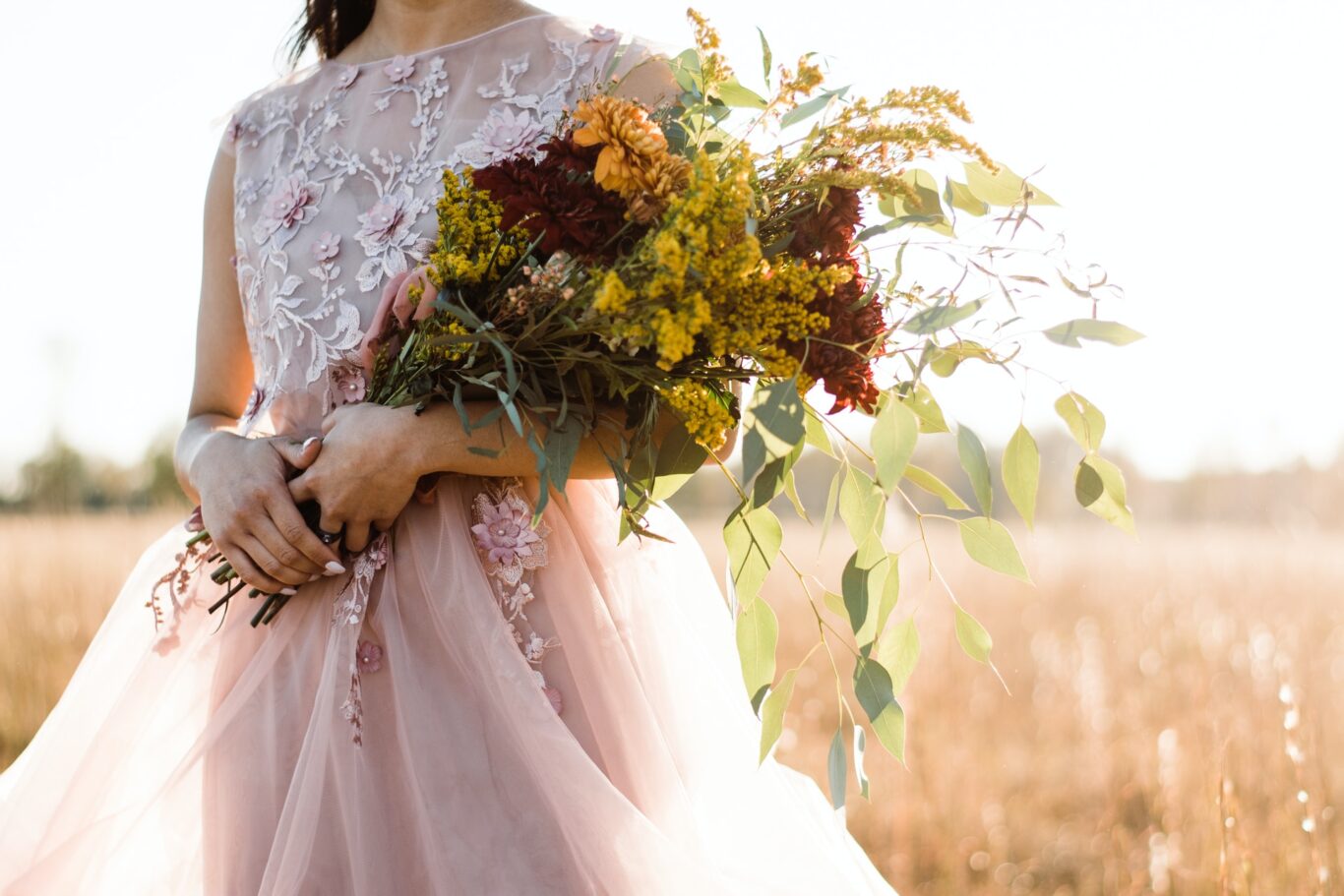 Φθινοπωρινός γάμος και γάμος ανά εποχή woman in pink and silver sleeveless dress holding bouquet of flowers